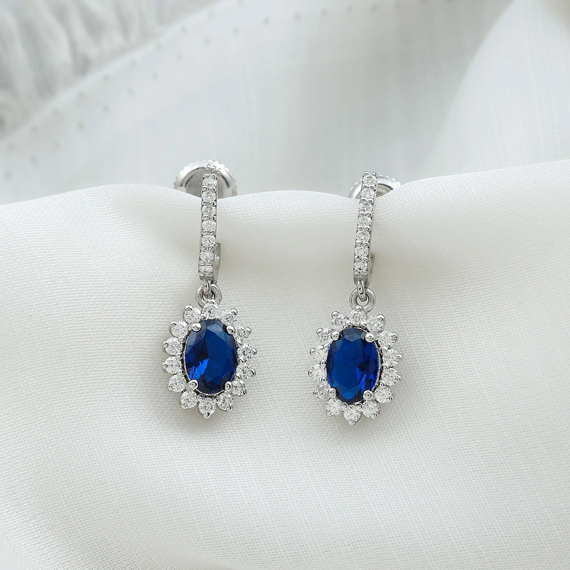 Oval Created Blue Sapphire J Hoop Earrings with Moissanite Halo